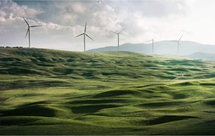 Energy-generating wind turbines set against green fields