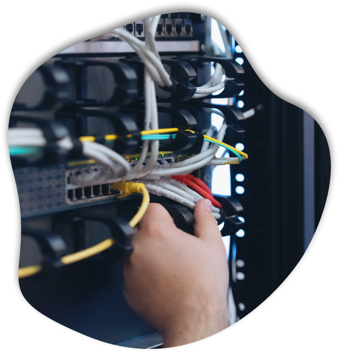 A person inserting ethernet cables into a PLC Panel